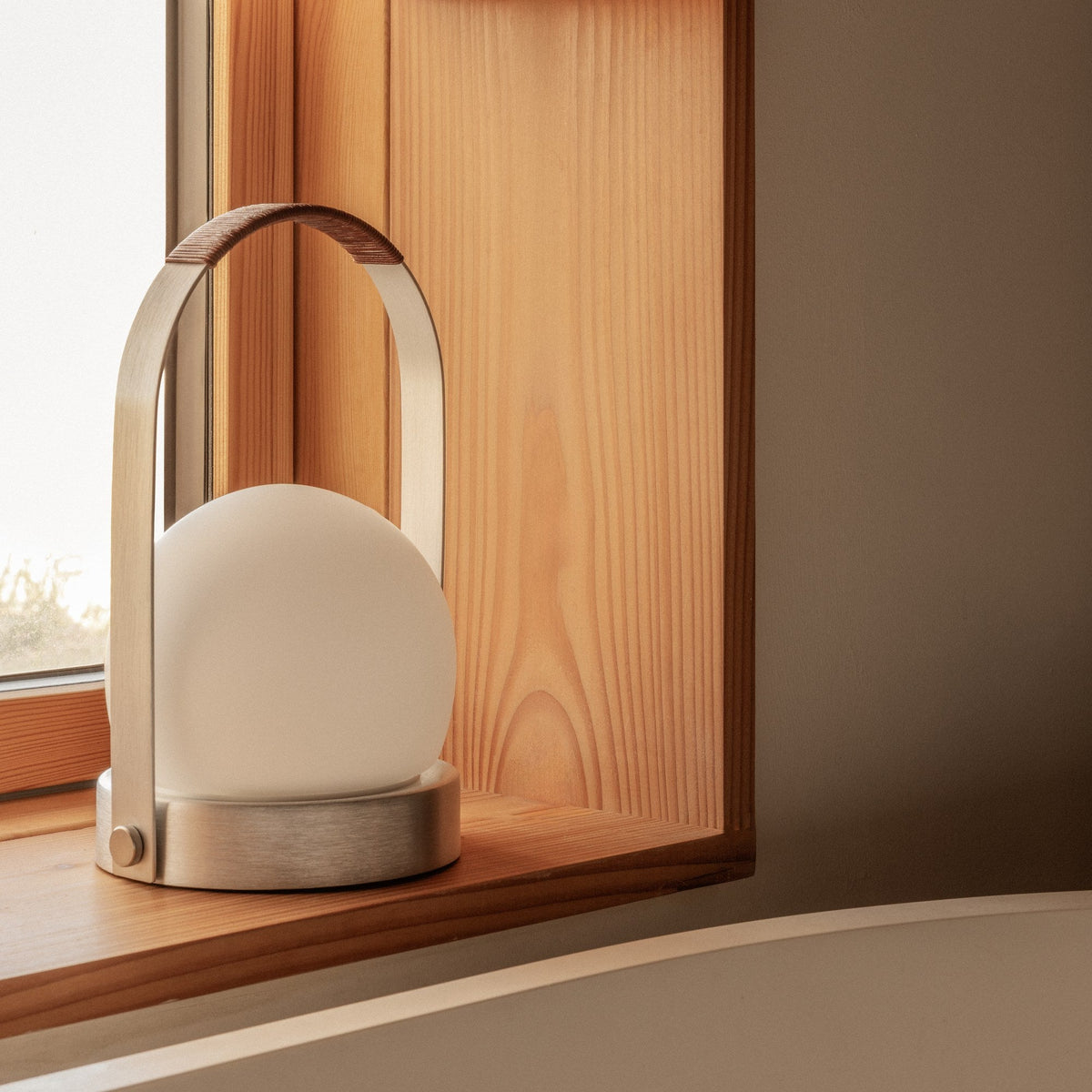 Audo Copenhagen Carrie LED Lamp Brushed Aluminium Leather on a window sill - KANSO#Color_Brushed Aluminium Leather
