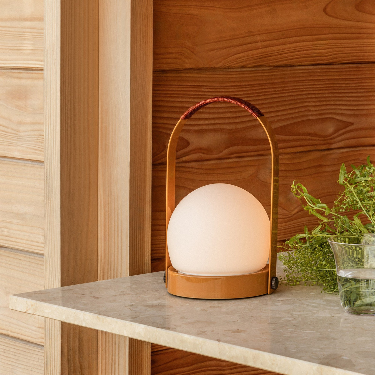 Audo Copenhagen Carrie LED Lamp Golden Brown Leather lit on a terrazzo table - KANSO#Color_Golden Brown Leather