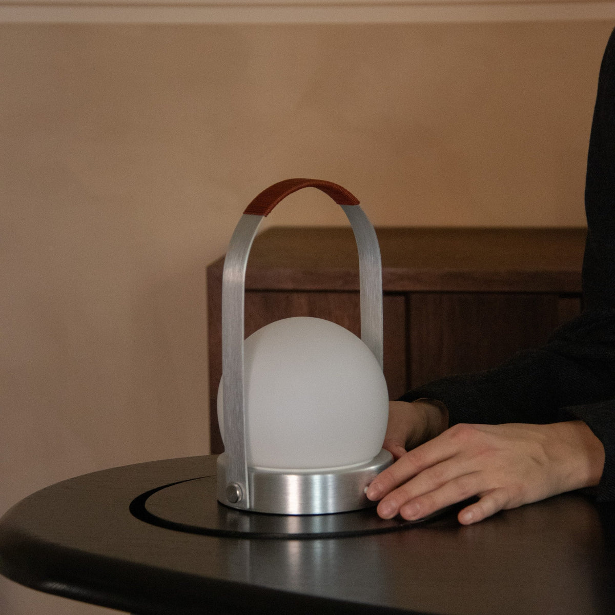 Audo Copenhagen Carrie LED Lamp Brushed Aluminium Leather on a black table - KANSO#Color_Brushed Aluminium Leather