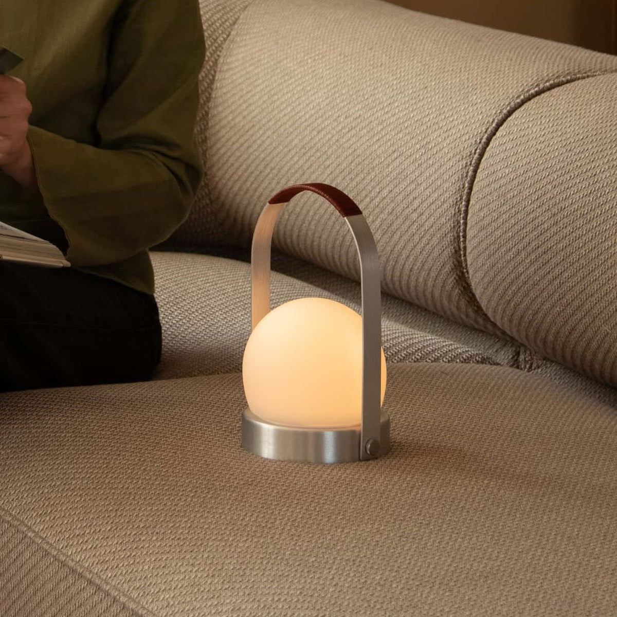 Audo Copenhagen Carrie LED Lamp Brushed Aluminium Leather on a sofa - KANSO#Color_Brushed Aluminium Leather