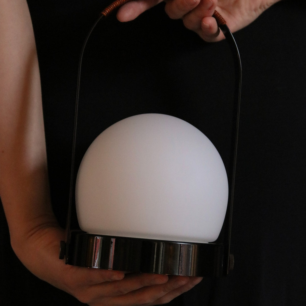 Audo Copenhagen Carrie LED Lamp Black Leather carried by the handle - KANSO#Color_Black Leather