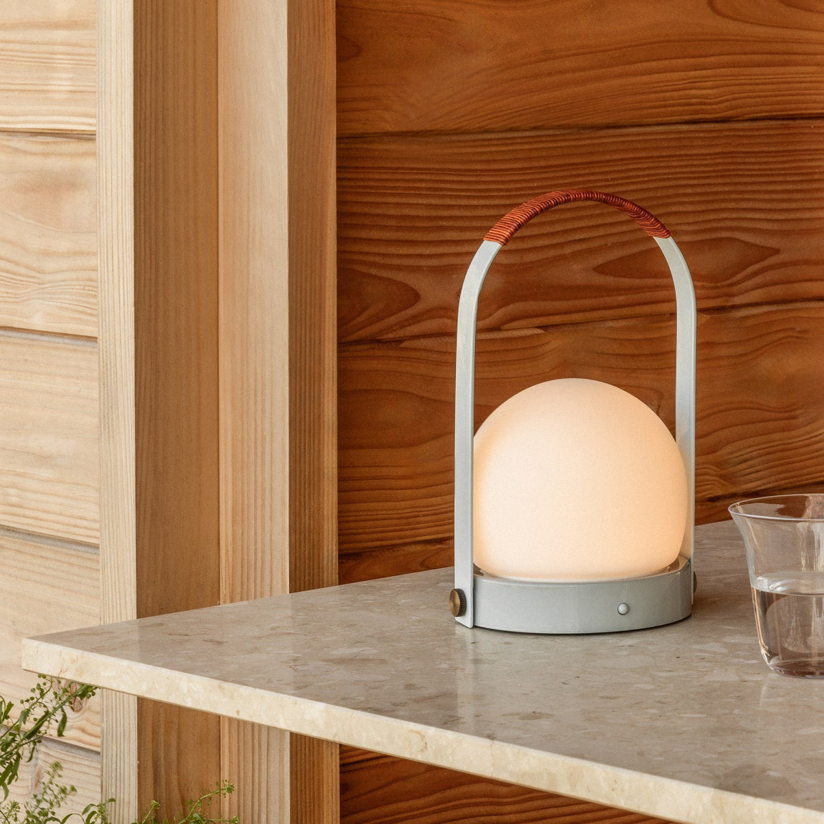 Audo Copenhagen Carrie LED Lamp Linen Blue Leather lit on a terrazzo table - KANSO#Color_Linen Blue Leather