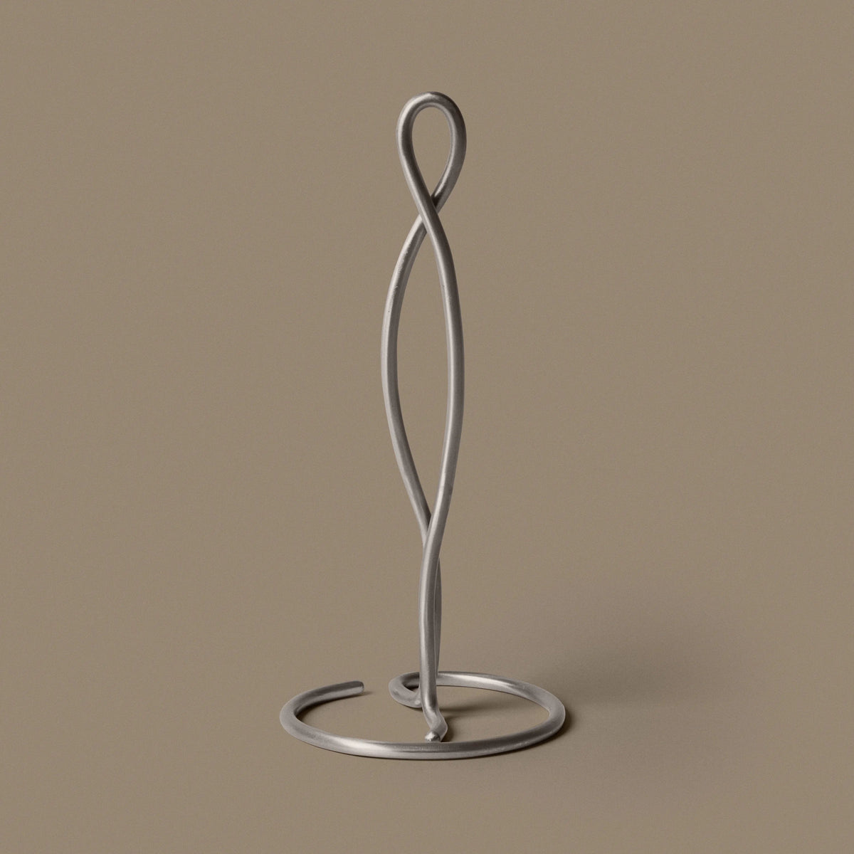 ferm Living Curvature Paper Towel Holder, Stainless Steel, on a tan background - KANSO#Color_Stainless Steel