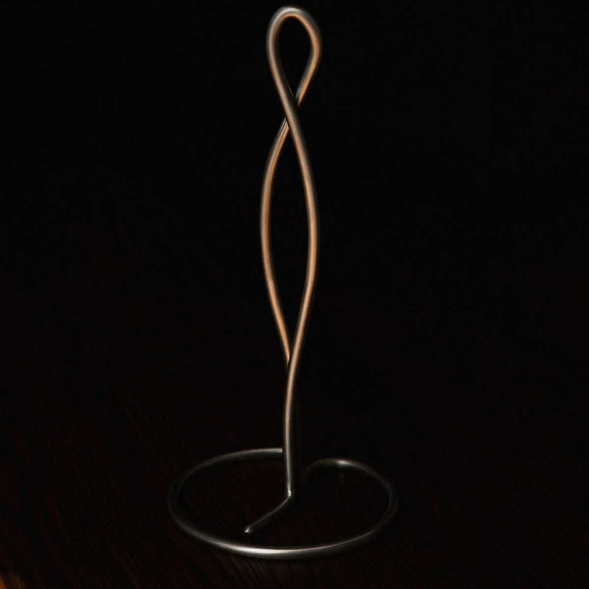 ferm Living Curvature Paper Towel Holder, Stainless Steel, on a dark wood surface - KANSO#Color_Stainless Steel