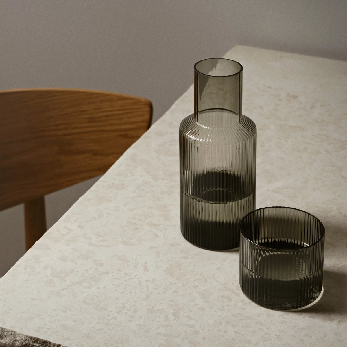 ferm Living Ripple Carafe Set - Small, Smoked Grey, on a stone table - KANSO#Color_Smoked Grey